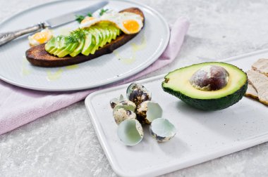 Siyah ekmek tost yumurta ile Avacado sandviç. Gri arka, yan görünüm
