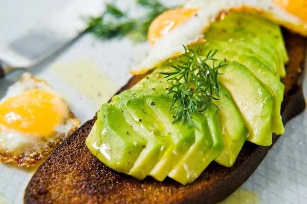 Siyah ekmek tost yumurta ile Avacado sandviç. Gri arka plan, yan görünüm, yakın çekim