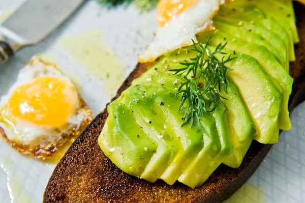 Siyah ekmek tost yumurta ile Avacado sandviç. Gri arka plan, yan görünüm, yakın çekim