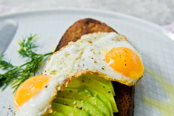 Siyah ekmek tost yumurta ile Avacado sandviç. Gri arka plan, yan görünüm, yakın çekim