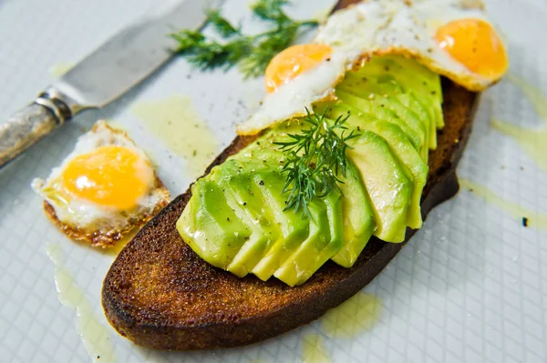 Siyah ekmek tost yumurta ile Avacado sandviç. Gri arka plan, yan görünüm, yakın çekim