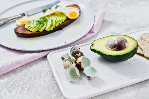 Siyah ekmek tost yumurta ile Avacado sandviç. Gri arka, yan görünüm
