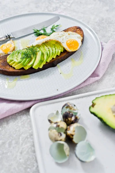 Siyah ekmek tost yumurta ile Avacado sandviç. Gri arka, yan görünüm