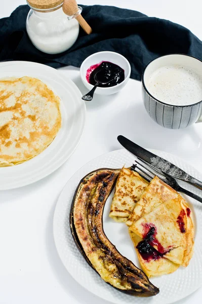 Böğürtlenli reçel, kahvaltı kahve ile geleneksel Rusça krep. Beyaz arka plan, üstten görünüm, yakın çekim