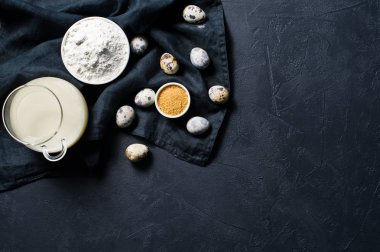 Gluten free yemek ve laktoz ücretsiz pişirme kavramı. Malzemeler: muz, Bıldırcın yumurta, şeker, gluten ücretsiz un, yulaf sütü. Siyah arka plan, üstten görünüm, metin için yer