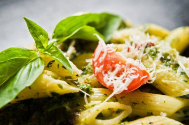 Ispanak, domates ve fesleğen ile İtalyan makarna Penne. Siyah arka plan, üstten görünüm, yakın çekim