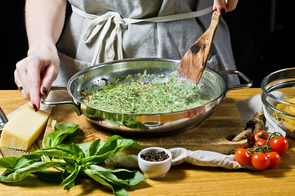 Kocken Förbereder Sås Spenat Och Grädde Penne Pasta Svart Bakgrund — Stockfoto
