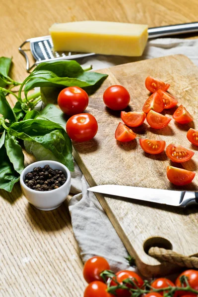 Sliced cherry tomatoes on a wooden chopping Board. Black background, side view, space for text