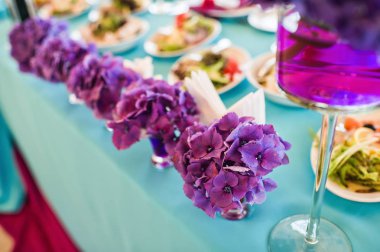 Akşam yemeği düğün mor çiçekler ile dekore edilmiş restoran tabloda