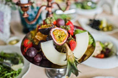 Meyve plaka tutku meyve, kavun, ananas, çilek ve kivi Restoran, tablo ile şenlikli bir aile yemeği