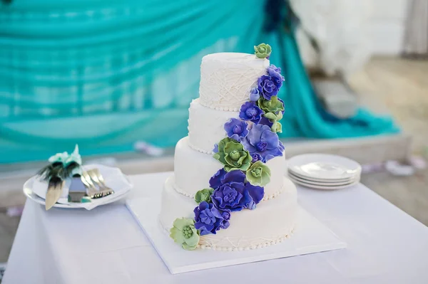 White wedding cake decorated with blue flowers