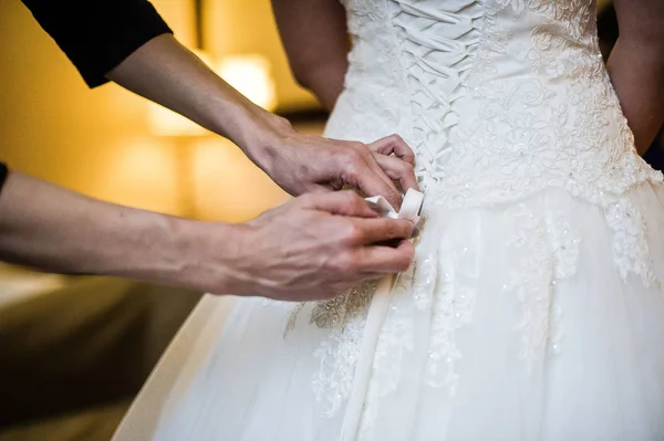 The bride is helped to wear a wedding dress, the interior of the hotel