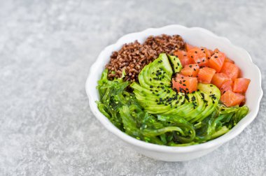 Somon salata, avokado, kahverengi pirinç, deniz yosunu. Gri arka plan, üstten görünüm, metin için yer