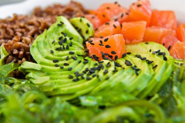 Poke kase. Malzemeler: somon, avokado, kahverengi pirinç, yosun. Gri arka plan, üstten görünüm, yakın çekim