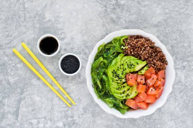 Somon salata, avokado, kahverengi pirinç, deniz yosunu. Gri arka plan, yan görünüm, metin için yer