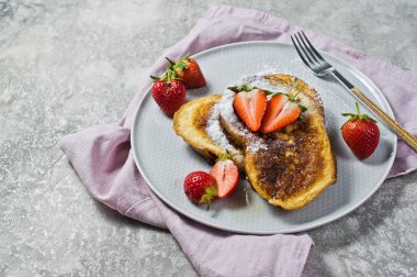 Üzerinde çilek ile geleneksel Fransız tostu. Gri arka, yan görünüm