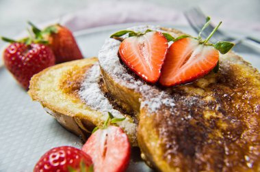 Çilek ve akçaağaç şurubu ile Fransız tostu. Gri arka plan, yan görünüm, yakın çekim