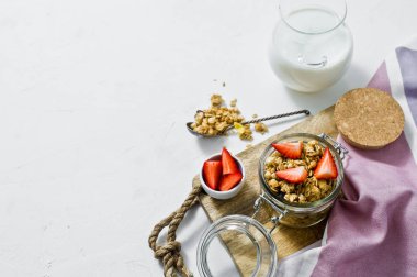 Cam kavanozda çilek müsli. Beyaz arka plan, yan bakış, metin için yer. Sağlıklı vegan snack