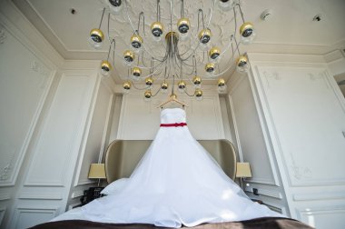 Gelinin avize otel odasında asılı beyaz gelinlik