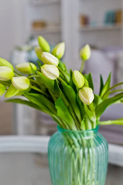 Jarrón con tulipanes amarillos en la mesa de la habitación. Fondo interior con estilo . — Foto de Stock