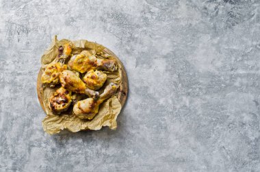 Barbekü tavuk budu ile Kraft kağıt tepsisindeki. Gri arka plan, üstten görünüm, metin için yer.