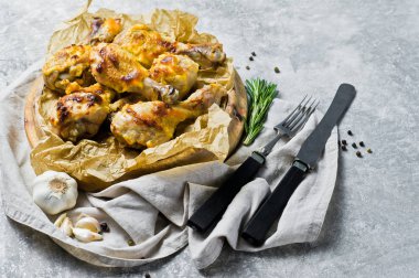 Kraft kağıt ile bir tepsi üzerinde ızgara tavuk budu. Gri arka plan, üstten görünüm, metin için yer.