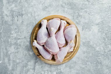 Çiğ tavuk budu. Gri arka plan, üstten görünüm, metin için yer.