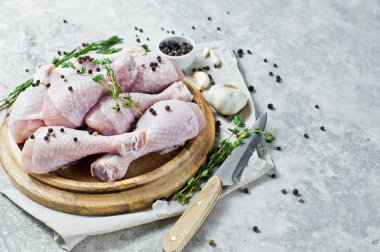 Tavuk bacağı çeyrek. Yemek pişirmek için malzemeler: biberiye, kekik, sarımsak, biber. Gri arka, yan görünüm.