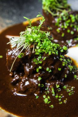 Fırında kuzu sos ve otlar, koyu arka plan, üstten görünüm