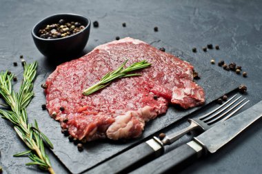 Bir taş kurulu rosemary ile sığır eti biftek. Siyah arka plan, üst