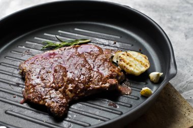 Barbekü biftek tavada sığır eti. Gri arka plan, üstten görünüm, uzay için 