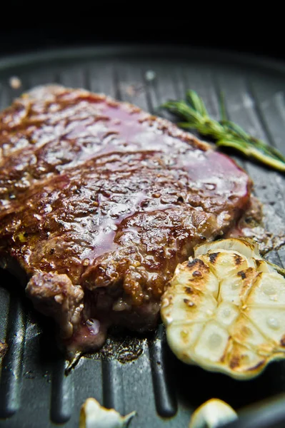 Bistecca nella padella. Fondo scuro, vista laterale, messa a fuoco selettiva — Foto Stock