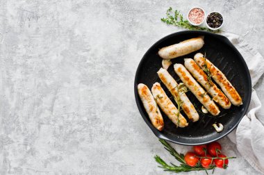 Bir kızartma tavasında çeşitli kızarmış sosis, domuz eti, sığır eti, tavuk, tu