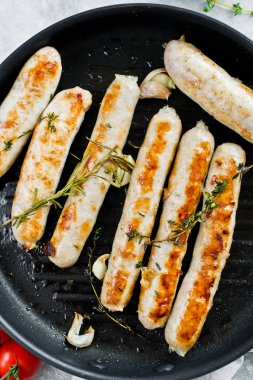 Bir kızartma tavasında çeşitli kızarmış sosis, domuz eti, sığır eti, tavuk, tu