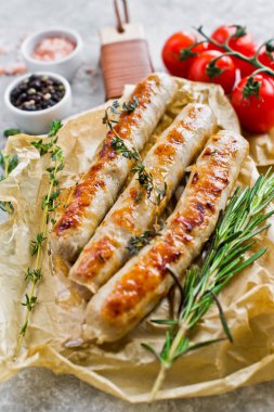 Ahşap bir tahta doğrama üzerinde kızarmış domuz sosis. Gri arka plan,