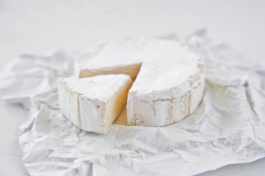 Beyaz kağıda Camembert. Beyaz arka plan, yan görünüm