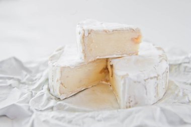Beyaz kağıda camembert peyniri. Beyaz arka plan, yan görünüm, CL