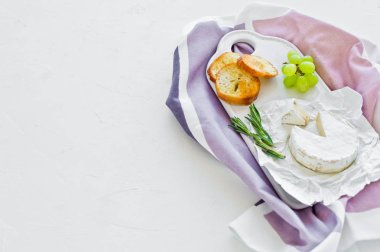 Beyaz bir kesme tahta üzerinde fındık ile camembert peyniri, üzüm, Ros