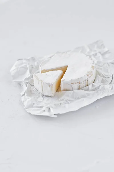 Camembert sur papier blanc. Fond blanc, vue latérale — Photo