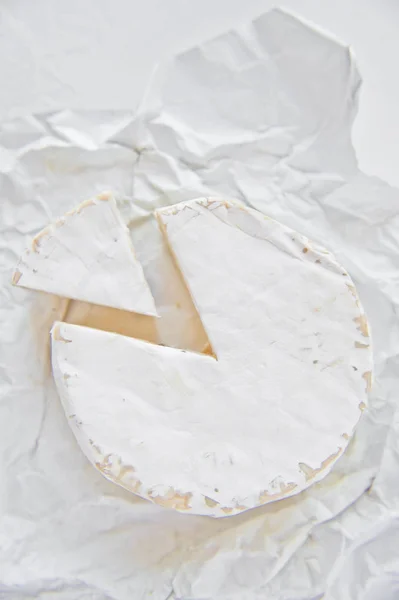 Τυρί Μπρι σε Λευκή Βίβλο. Λευκό φόντο, επάνω όψη, κοντινό — Φωτογραφία Αρχείου