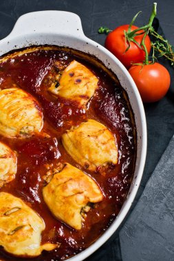 Çanak ile domates soslu fırında kalamar dolması. Siyah arka plan,