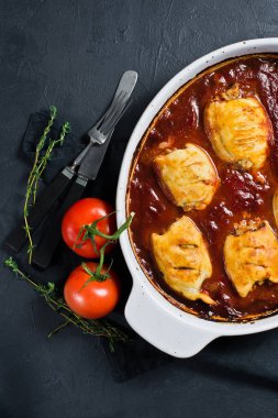 Çanak ile domates soslu fırında kalamar dolması. Siyah arka plan,