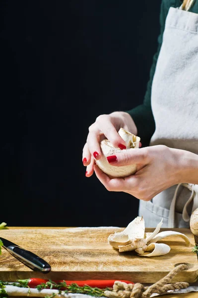 Le chef nettoie le champignon. Fond noir, vue latérale, cuisine — Photo