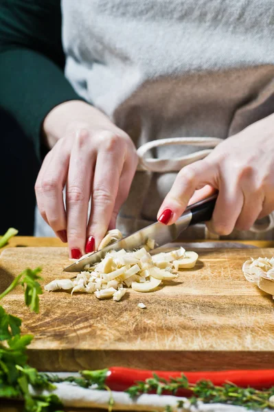 Mãos de chef cortando um cogumelo. Fundo preto, vista lateral, k — Fotografia de Stock