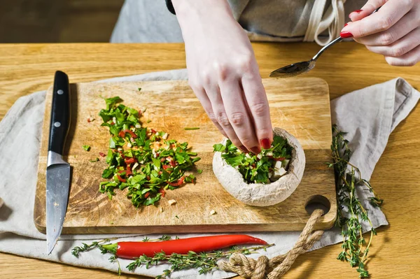 Lo chef prepara funghi ripieni. sfondo nero, vista laterale — Foto Stock