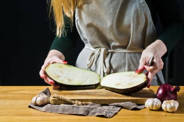 Şef patlıcan bir ahşap kesme tahtası dilimleme. Yan