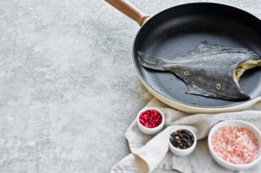 Pan çiğ pisi balığı. Gri arka plan, üstten görünüm, metin için yer.