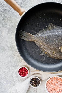 Pan çiğ pisi balığı. Gri arka plan, üstten görünüm.