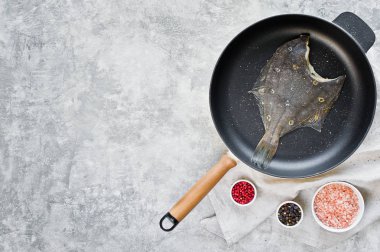 Pan çiğ pisi balığı. Gri arka plan, üstten görünüm, metin için yer.