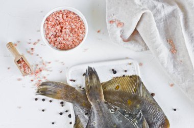 Ham yaldızlı pisibalığı, yemek pişirmek için malzemeler. Beyaz arka plan, üstten görünüm.